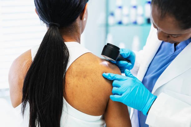 Dermatologist examining patient's skin
